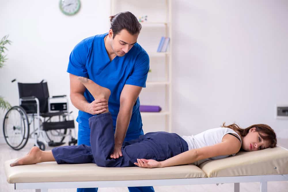 Frisco rehabilitative excercises by ostepath assisting young woman with stretches