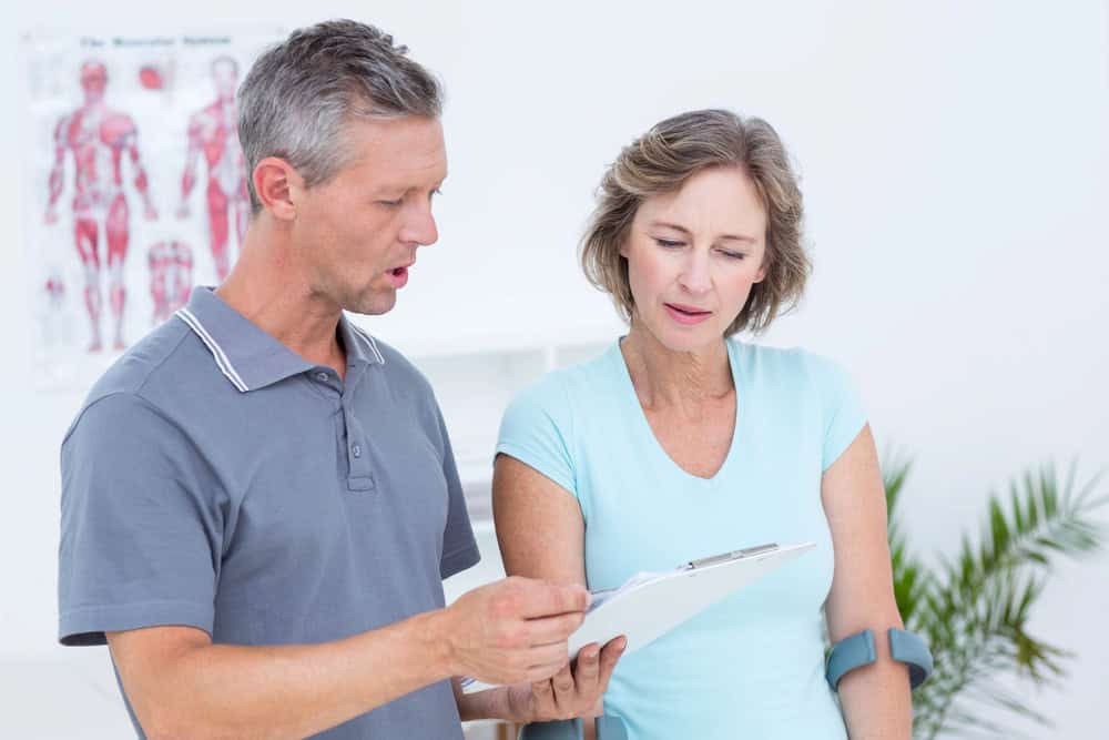 physical therapist showing a woman an excercise treatment plan